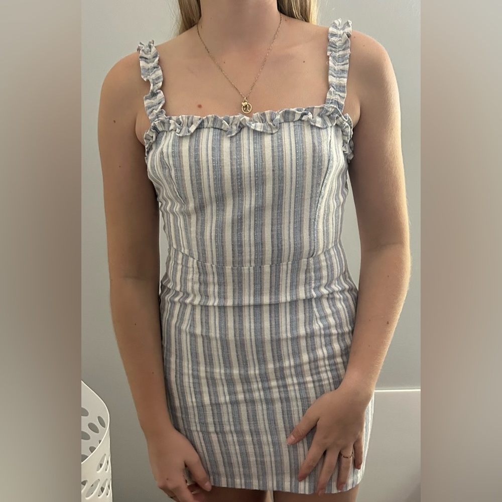 Mini dress with an open back,zipper,and a bow in back with non adjustable straps